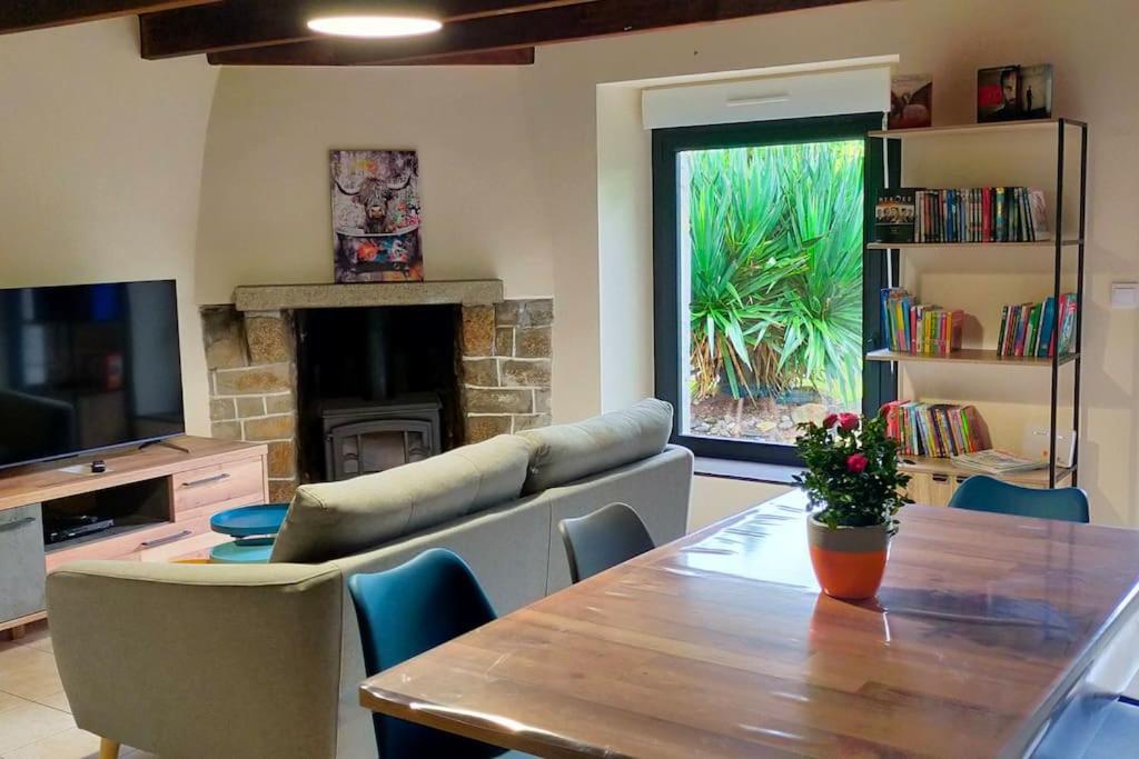 a living room with a table and a fireplace at Maison au calme bord de mer in Jullouville-les-Pins