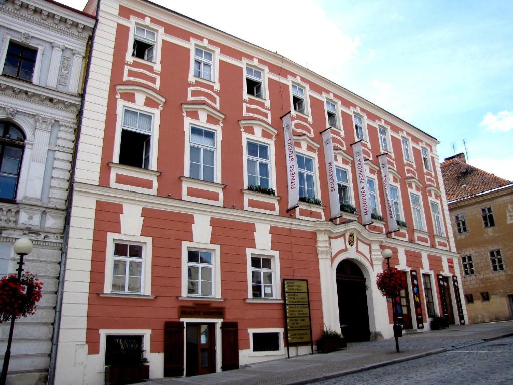 ein großes rotes Gebäude in einer Stadtstraße in der Unterkunft Palác Daun - Studio Apartments in Znojmo