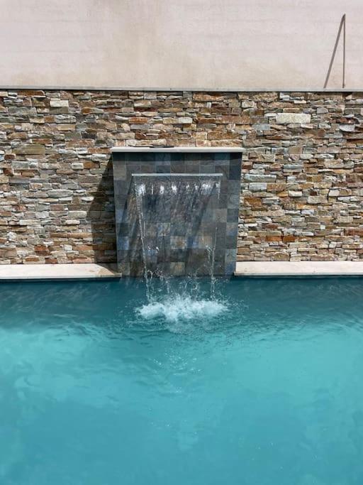 une fontaine au milieu d'un bassin d'eau dans l'établissement Villa avec piscine et place de parking proche centre ville, à Aix-en-Provence