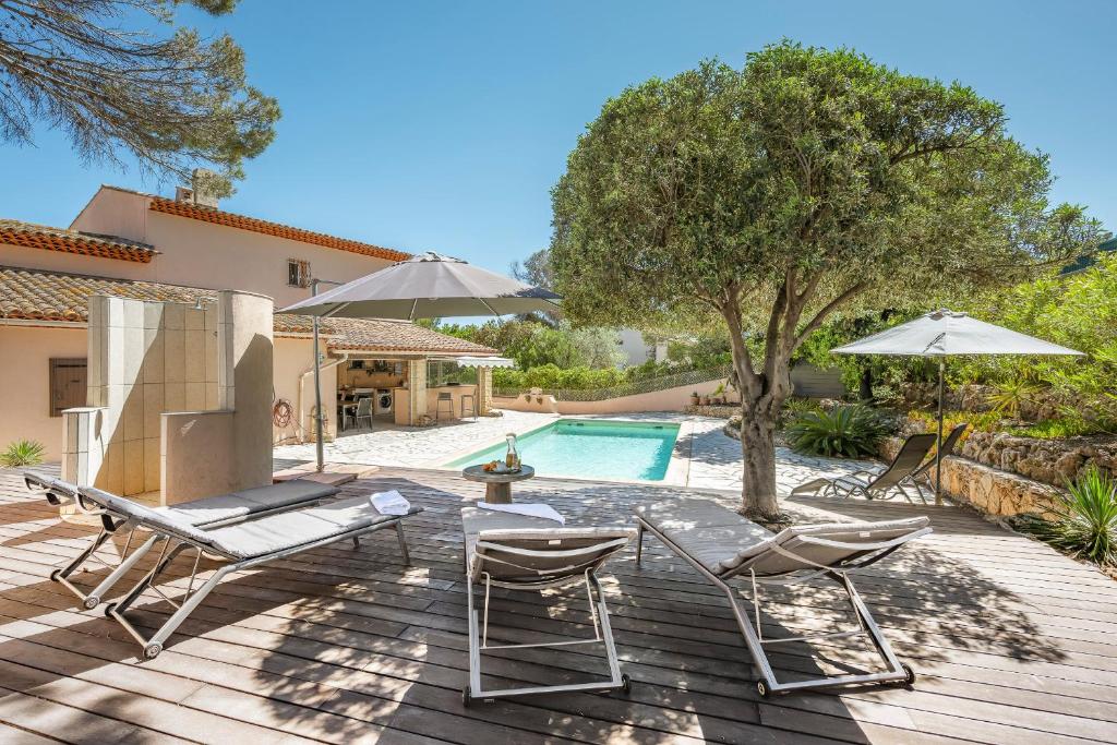 un patio avec deux chaises et une piscine dans l'établissement Charming villa in LES ISSAMBRES with SEA VIEW and swimming pool, aux Issambres