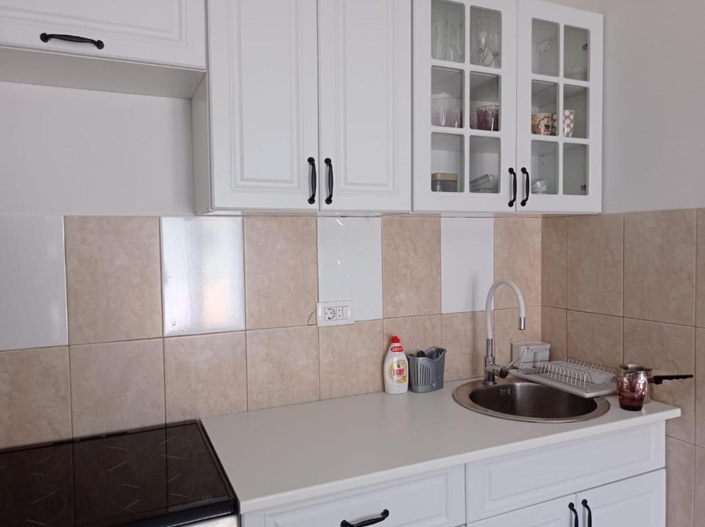a kitchen with white cabinets and a sink at A part hn in Herceg-Novi