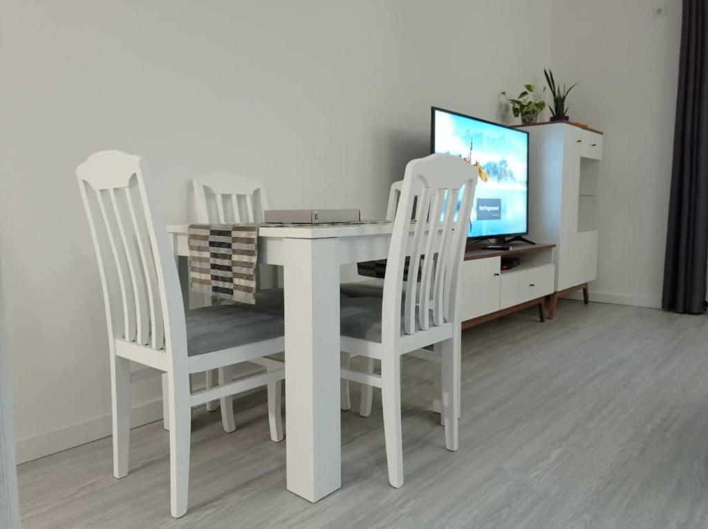 a white dining room table with two chairs and a television at A part hn in Herceg-Novi