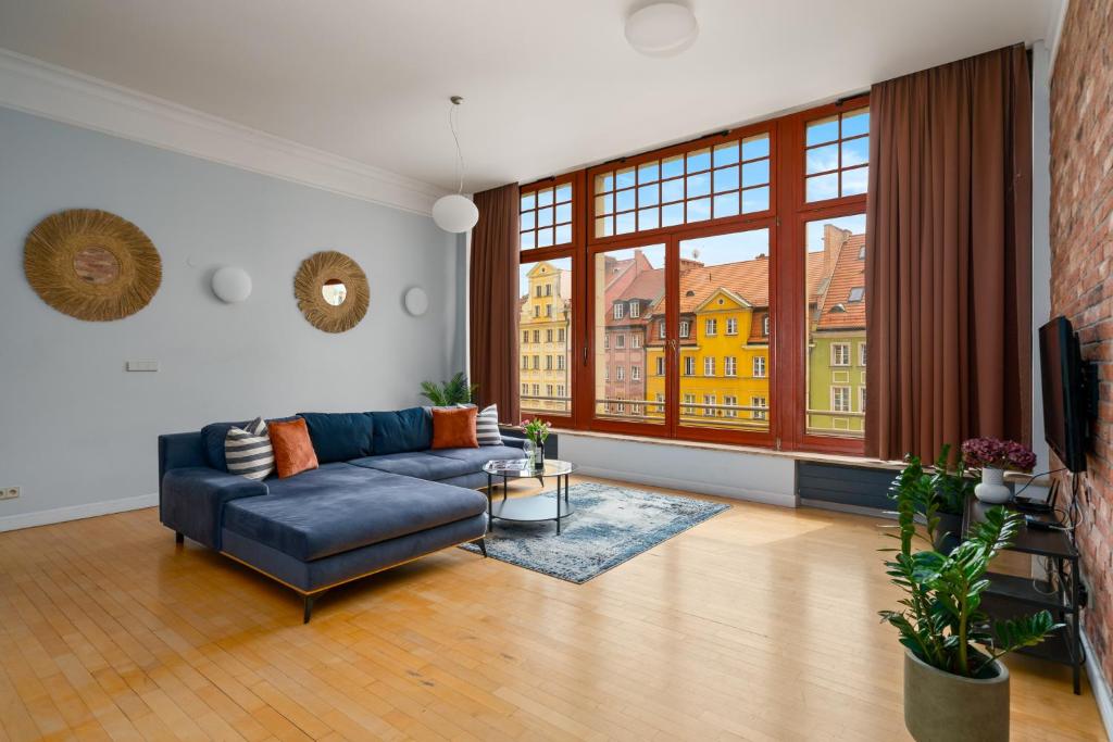 uma sala de estar com um sofá e uma grande janela em AS HOME Apartamenty Rynek 50 R503 em Breslávia