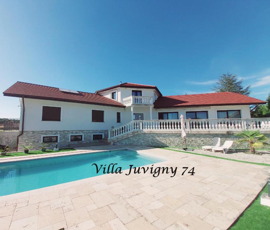 a house with a swimming pool in front of a house at Villa 5*, 15 personnes, Piscine à 20 min de Genève in Juvigny