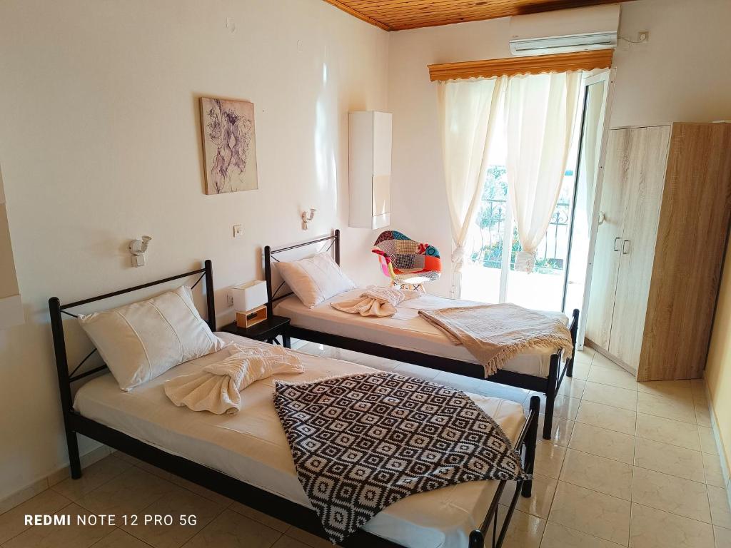 two twin beds in a room with a window at spasmata houses in Minia