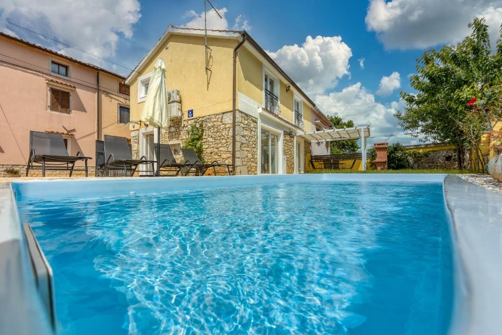 a swimming pool in front of a house at Casa Ti sei with Private Pool in Kaštelir