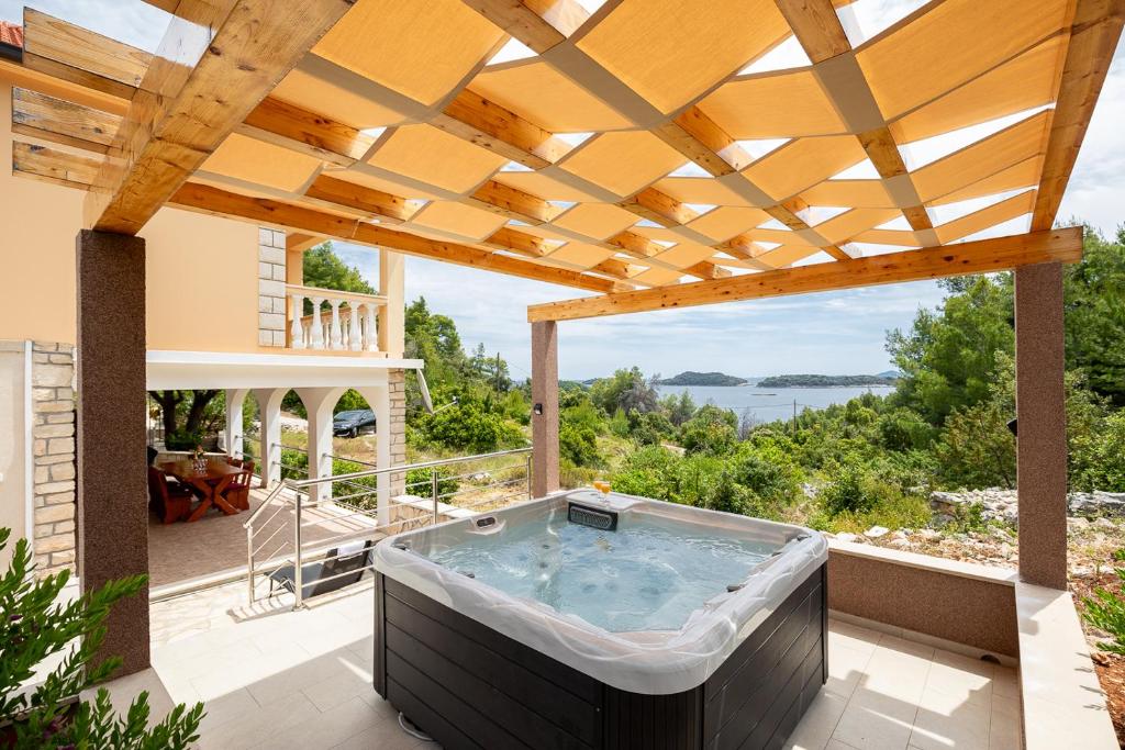wanna z hydromasażem na patio z drewnianą pergolą w obiekcie Villa Franciska w mieście Blato