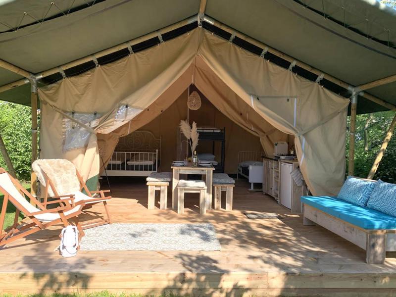 a tent with a couch and chairs and a table at De Tijnjehoeve in Boornzwaag