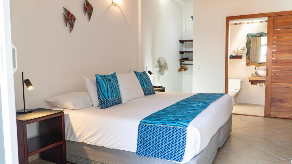 a bedroom with a bed with blue and white pillows at Hotel Galapagos Suites B&B in Puerto Ayora