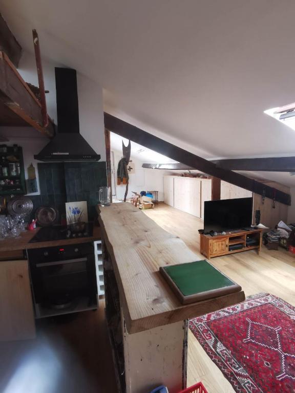 a kitchen with a wooden counter top in a room at Loft cosy et lumineux à Paris,Les Lilas dans un quartier convivial proche du métro 11 "Mairie des Lilas" et du tram T3b "porte des Lilas" in Bagnolet