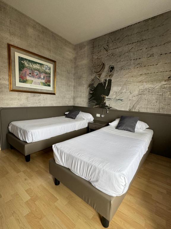 a bedroom with two beds and a painting on the wall at Sole Mare in Ventimiglia