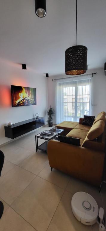 ein Wohnzimmer mit einem Sofa und einem Tisch in der Unterkunft Apartament JB 56m2 parking,balkon,2sypialnie in Legnica
