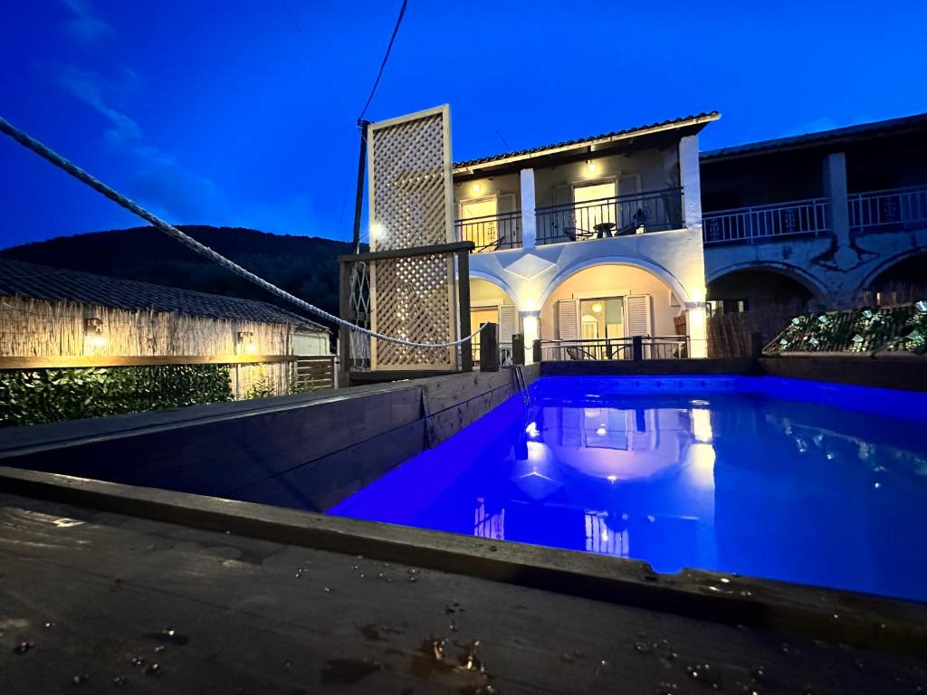 a villa with a swimming pool at night at Royal Jelly Suites in Marathias