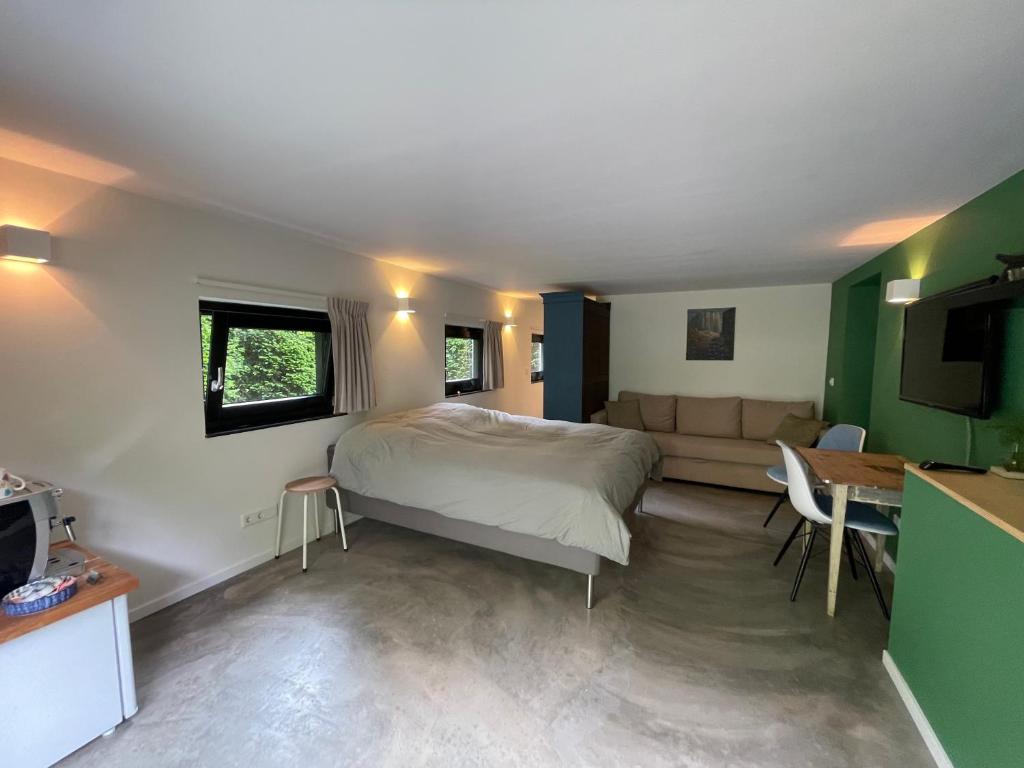 een slaapkamer met een bed, een bank en een tafel bij La Grange 28 in Bergen op Zoom