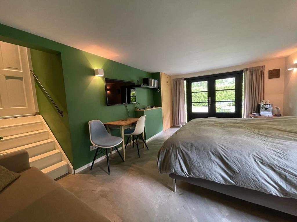 a bedroom with a bed and a table and chairs at La Grange 28 in Bergen op Zoom