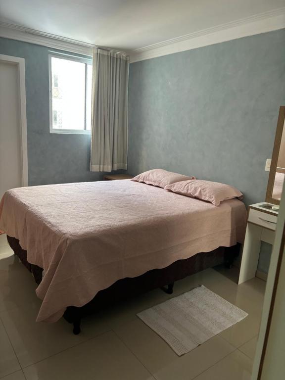 a bedroom with a large bed with a window at Belíssimo apartamento a 01 km da litorânea in São Luís