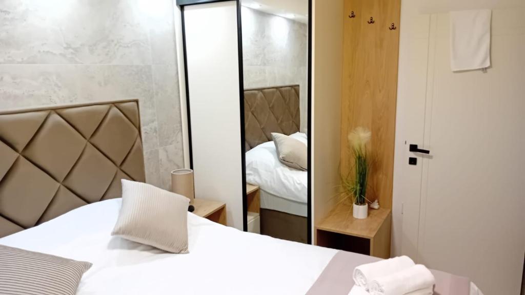 a bedroom with a white bed and a mirror at Square Point Apartments in Kotor