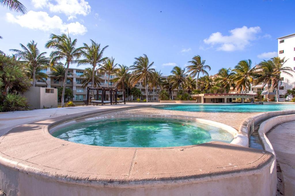 莫雷洛斯港的住宿－Luxury Beach Residences，一座棕榈树和建筑的大型游泳池