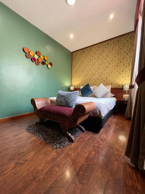 a bedroom with a bed and a couch and a chair at Pepe's House Cuenca I Hotel & Boutique Hostel in Cuenca