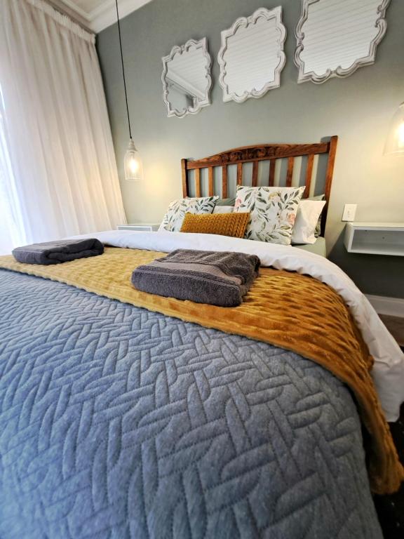 a bedroom with a large bed with a wooden headboard at Ceres Cozy Cottage in Ceres
