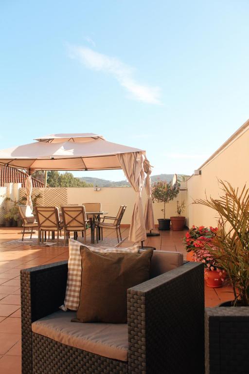 a patio with a couch and an umbrella at El Maltés in Cudillero