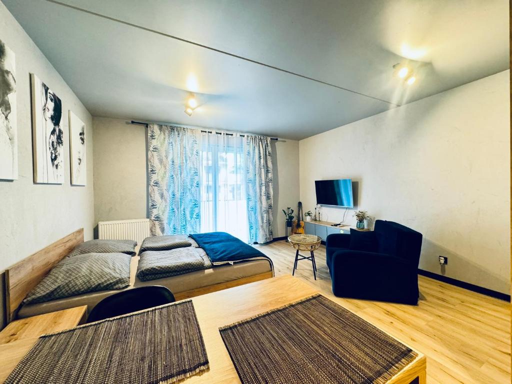 een slaapkamer met een bed, een bank en een tafel bij Loftowe Love in Kołobrzeg