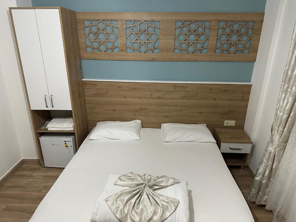a bedroom with a bed with a bow on it at Amsterdam Otel Economic Room in Kemer