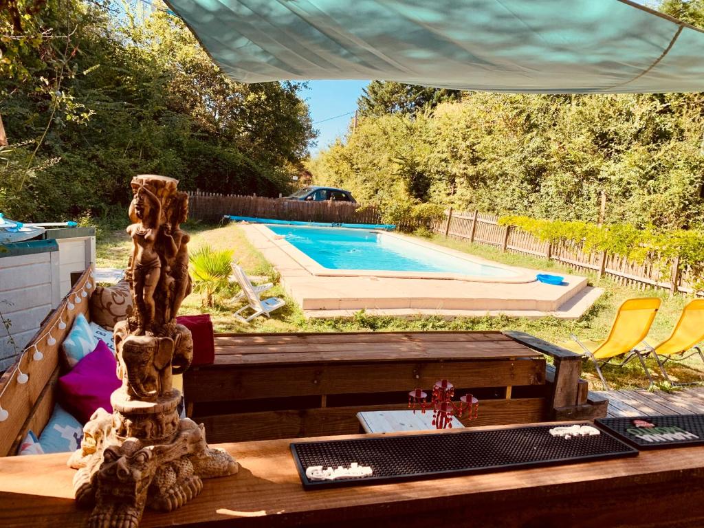 une table dans une cour arrière avec une piscine dans l'établissement Mathannaki, à Vendays-Montalivet