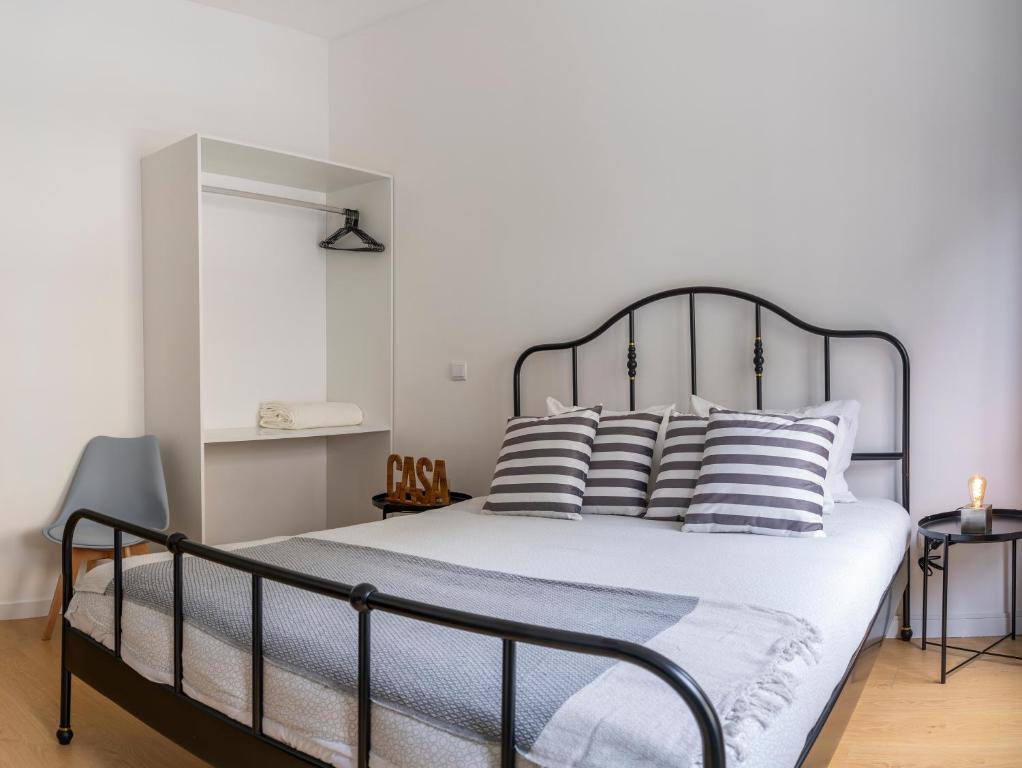 una camera da letto con un grande letto con cuscini a righe di Oporto Bonjardim Residence a Porto