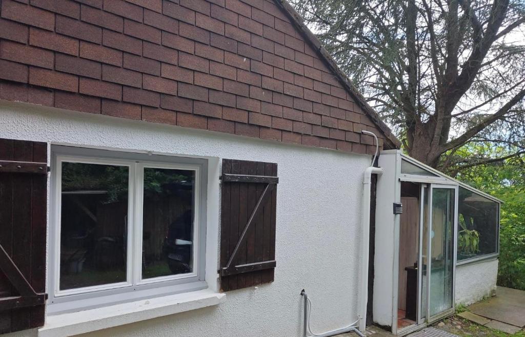 a white house with windows and a brown roof at studio gien in Gien