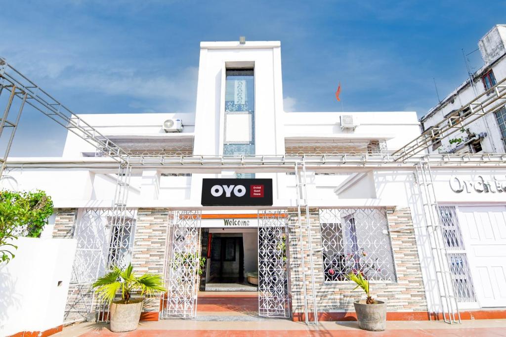 um edifício branco com um sinal qo em OYO Orchid Guest House em Durgapur