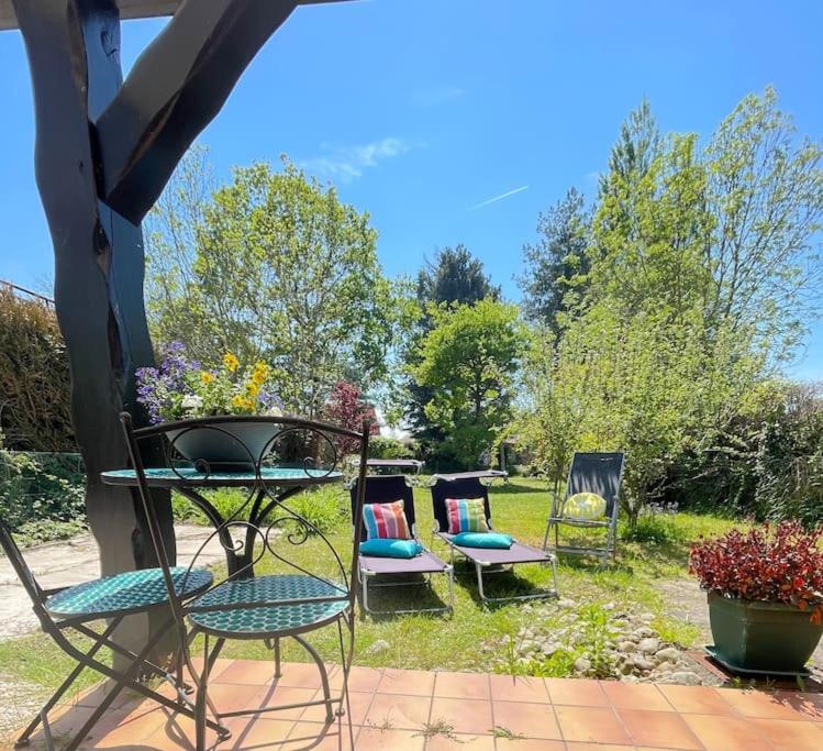 un groupe de chaises et de tables dans une cour dans l'établissement Charmante maison individuelle proche du Touquet, à Cucq