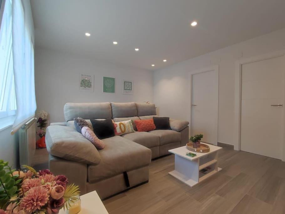 a living room with a couch and a table at Apartamento acogedor en La Camocha-Gijón in Monte de Huerces