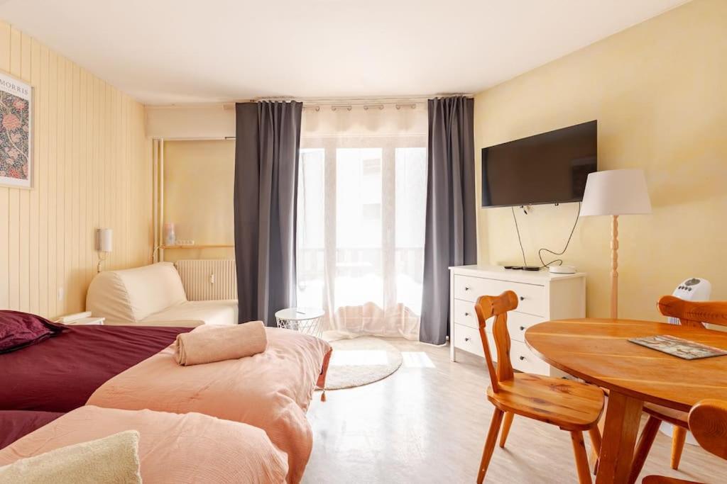 a bedroom with a bed and a table with a television at Studio central Brides-les-Bains in Brides-les-Bains