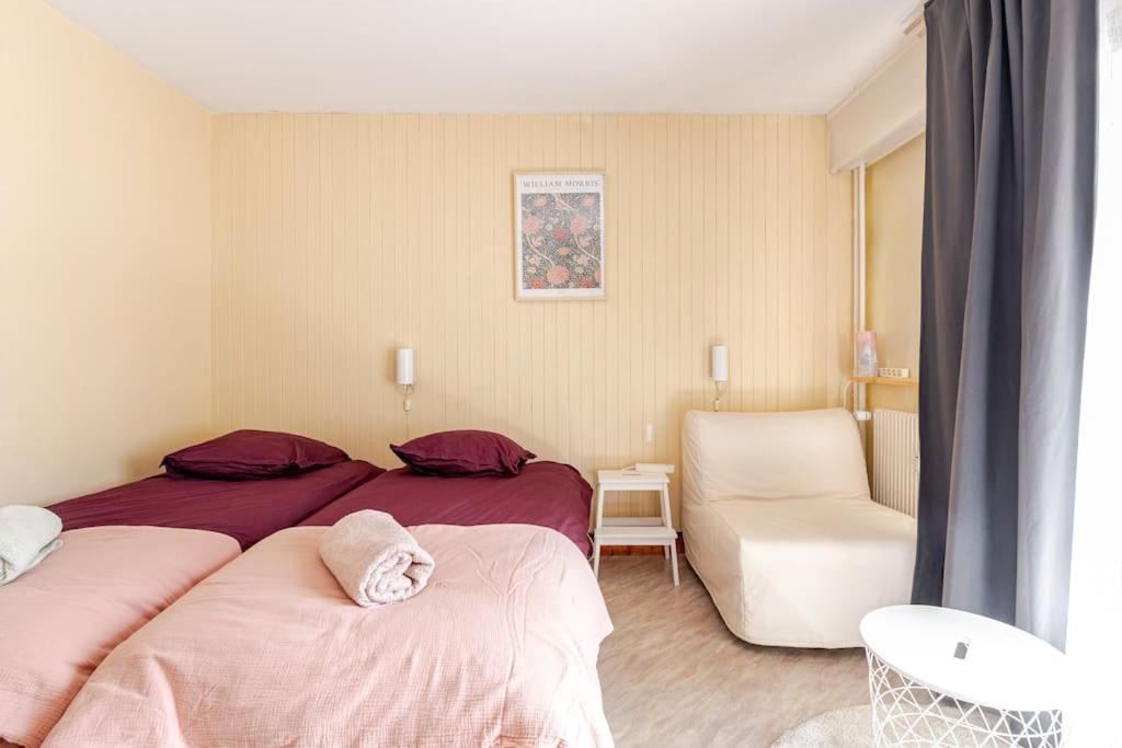 une chambre d'hôtel avec deux lits et une chaise dans l'établissement Studio central Brides-les-Bains, à Brides-les-Bains