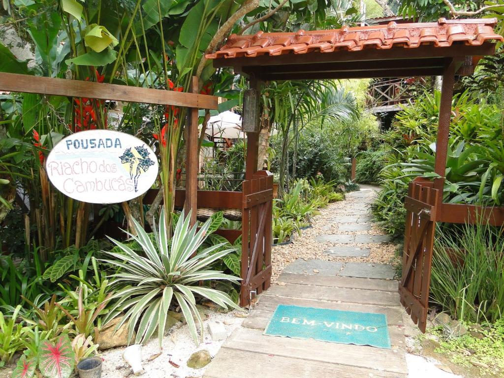un jardín con una puerta de madera y un cartel en Pousada Riacho Dos Cambucas en Ilha Grande