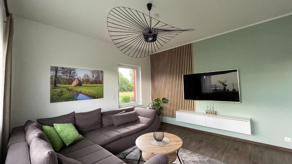 a living room with a couch and a flat screen tv at Ferienwohnung am Gurkenradweg in Werben