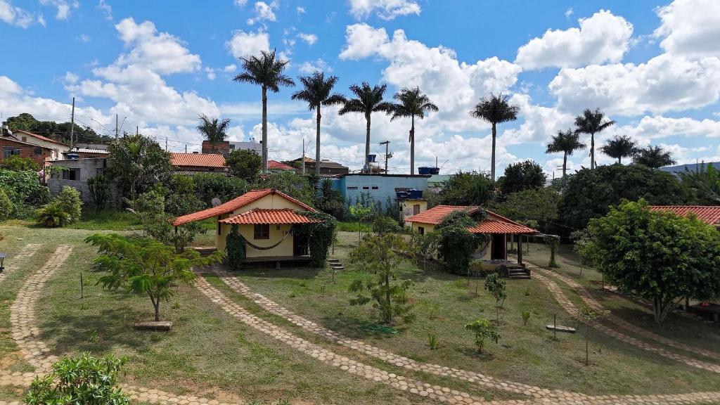 a small village with palm trees and a house at Chalés Vila Carrancas - Unidade Centro in Carrancas