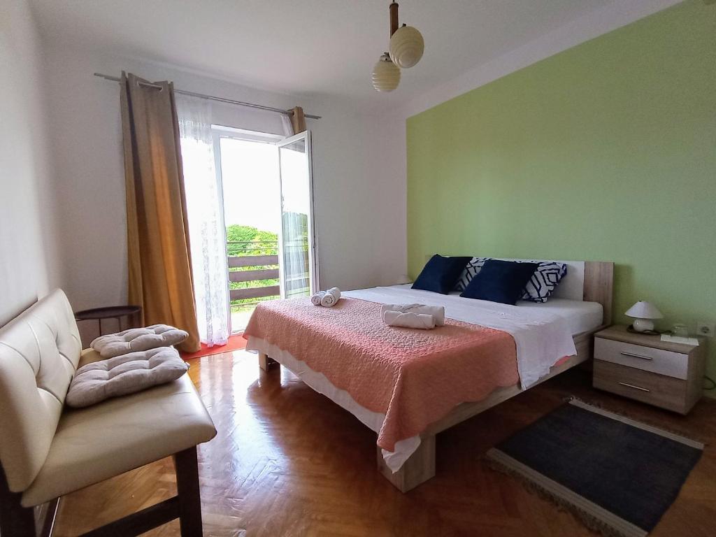 a bedroom with a bed and a couch and a window at B&B "Retro Gusto " in Pićan