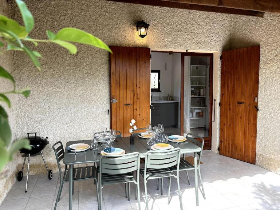 a table with chairs and plates and glasses on it at L'Escale aux portes des Gorges de l'Ardèche in Saint-Martin-dʼArdèche