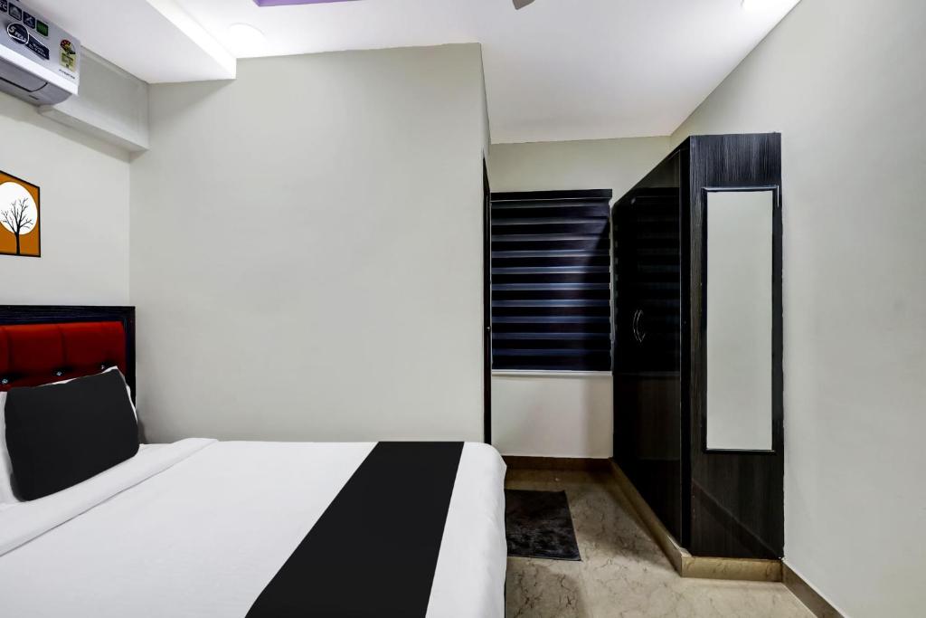 1 dormitorio con 1 cama y armario negro en OYO AADYA INN, en Tirupati