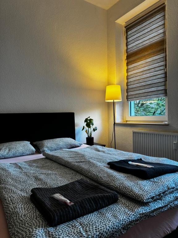 a bedroom with two beds and a lamp and a window at Cozy room in Central Dortmund in Dortmund