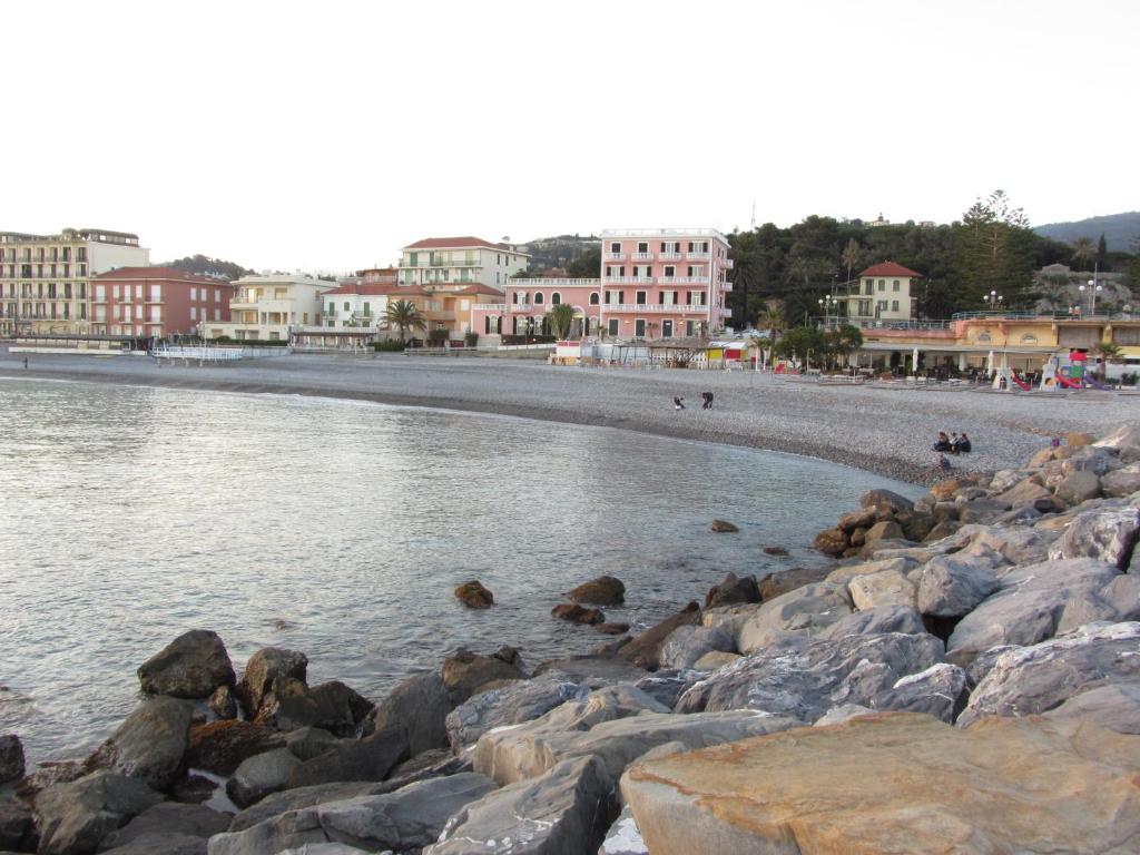 una spiaggia con rocce nell'acqua e negli edifici di La Casa Della Zia a Bordighera
