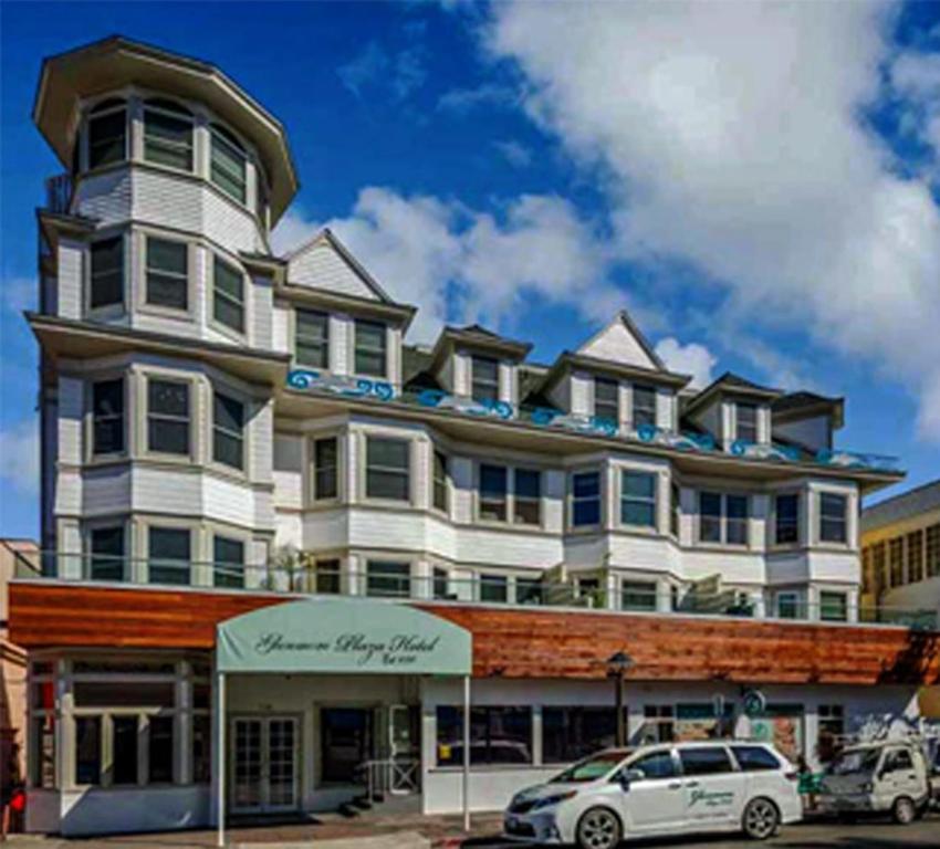a large white building with cars parked in front of it at Glenmore Plaza Hotel in Avalon