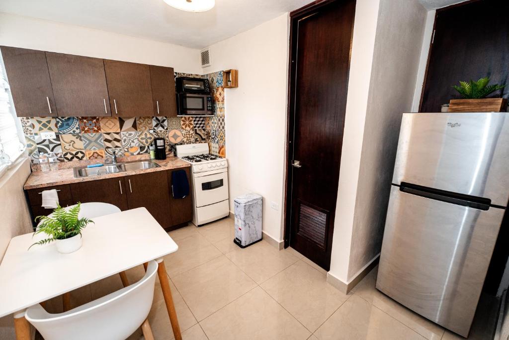 uma cozinha com um frigorífico e uma mesa em Private Patio Retreat with Zen Vibe and FREE Laundry em Ponce