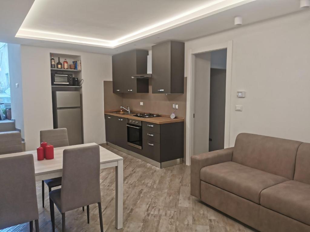 a kitchen and living room with a couch and a table at InCentro Millesimo in Millesimo