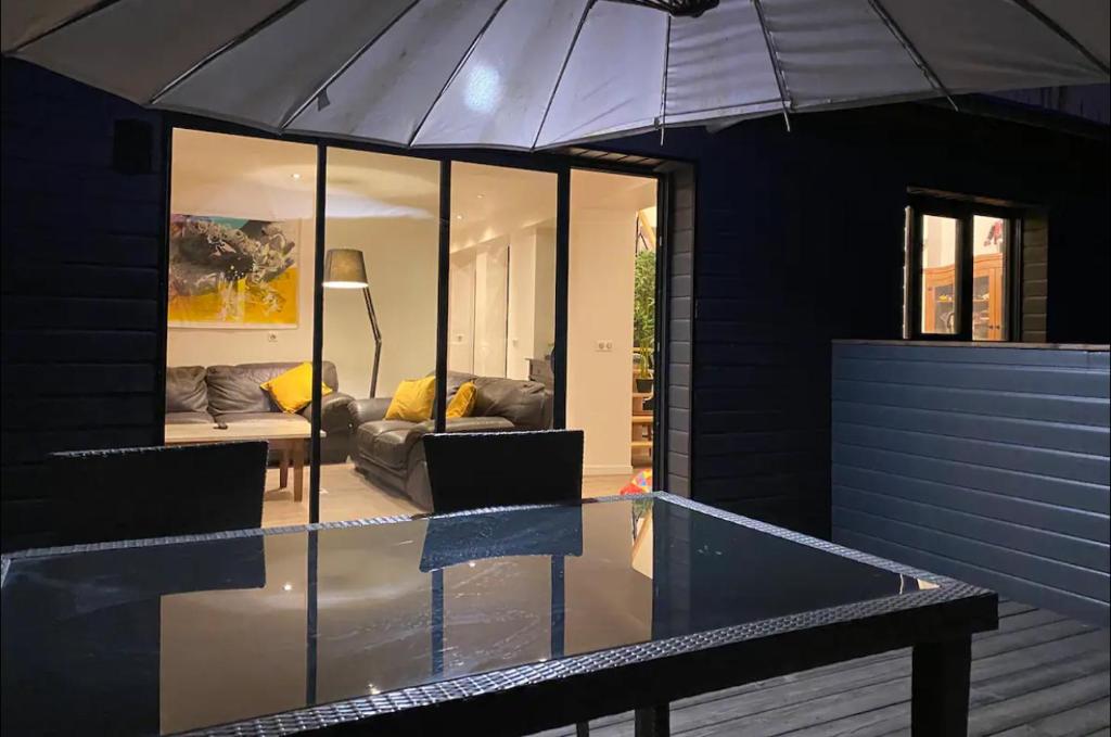 ein schwarzes Haus mit einem Tisch und einem Regenschirm in der Unterkunft Appartement climatisé avec sa terrasse de 25 M2 in Limoges