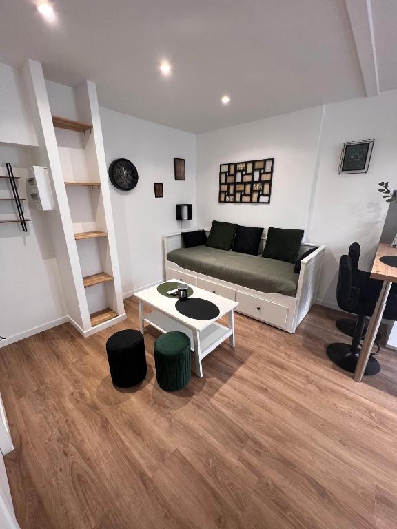un salon avec un canapé et une table dans l'établissement Les bords du Clain - Entrée Autonome Studio, à Poitiers