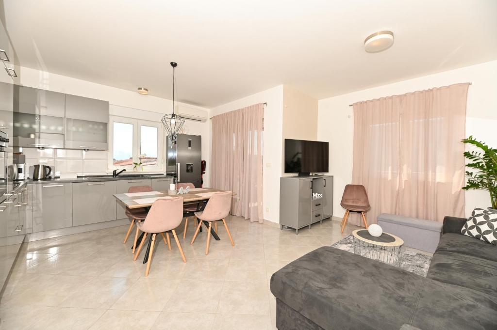 uma sala de estar com um sofá, uma mesa e uma cozinha em Apartment Marko em Trogir