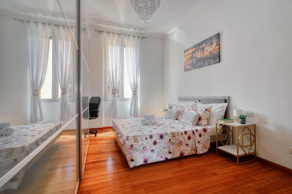 米蘭的住宿－Lattanzio Charming Suite - Porta Romana MM3，一间卧室设有两张床和玻璃墙